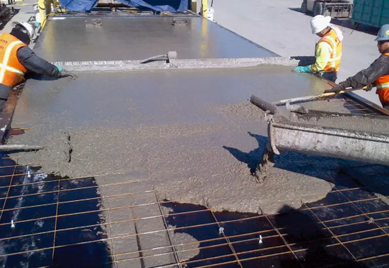 a man pouring concrete on a floor